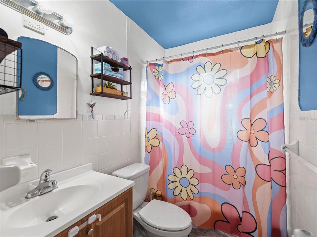 7114 Carlow Street New Port Richey, FL 34653 - Photo 22 of 65 a bathroom with a sink toilet and shower curtain