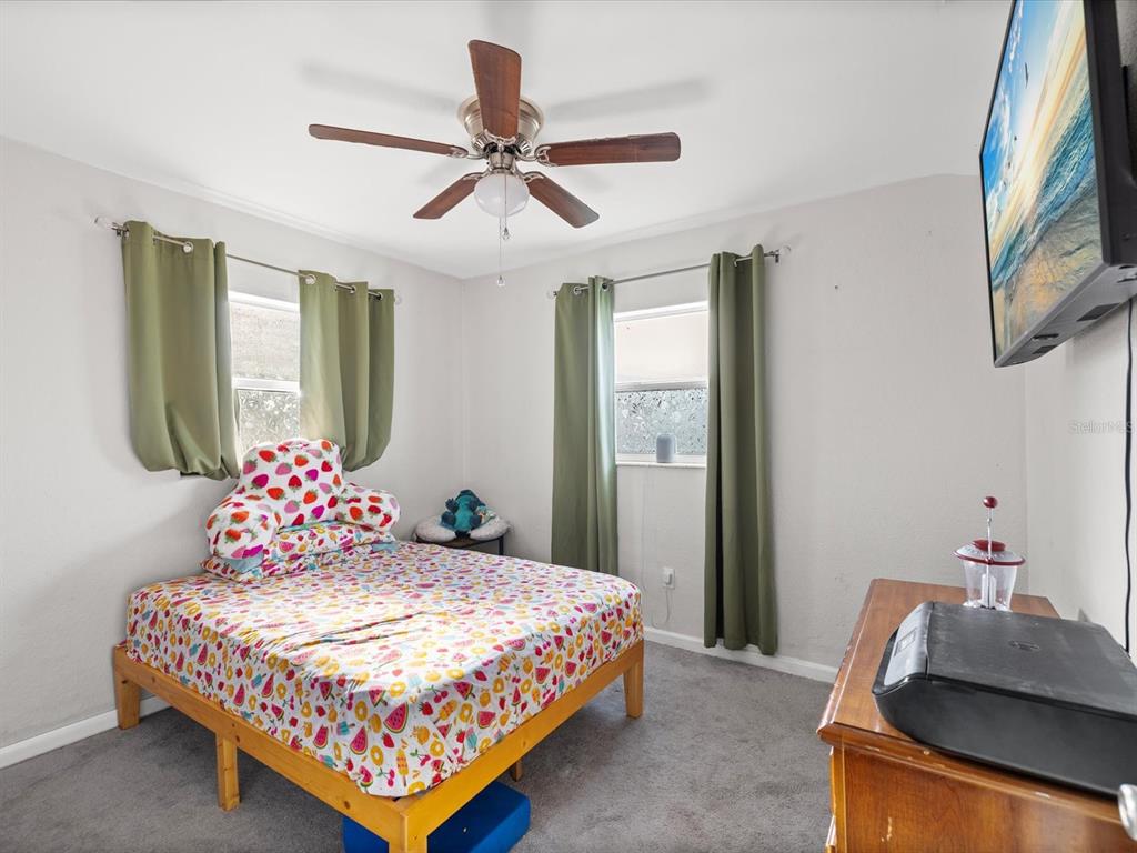 7114 Carlow Street New Port Richey, FL 34653 - Photo 23 of 65 a bedroom with a bed chandelier and a window