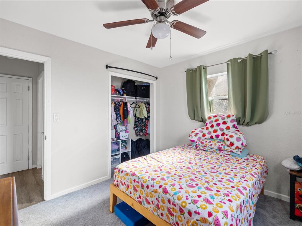 7114 Carlow Street New Port Richey, FL 34653 - Photo 24 of 65 a bedroom with a bed and a chandelier