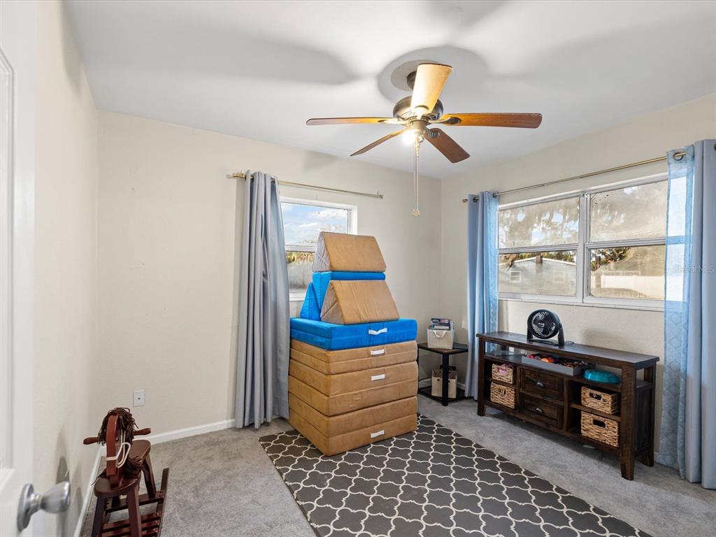 7114 Carlow Street New Port Richey, FL 34653 - Photo 25 of 65 a bedroom with furniture and a window