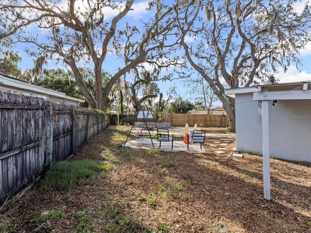 7114 Carlow Street New Port Richey, FL 34653 - Photo 33 of 65 a view of backyard with wooden fence and large trees