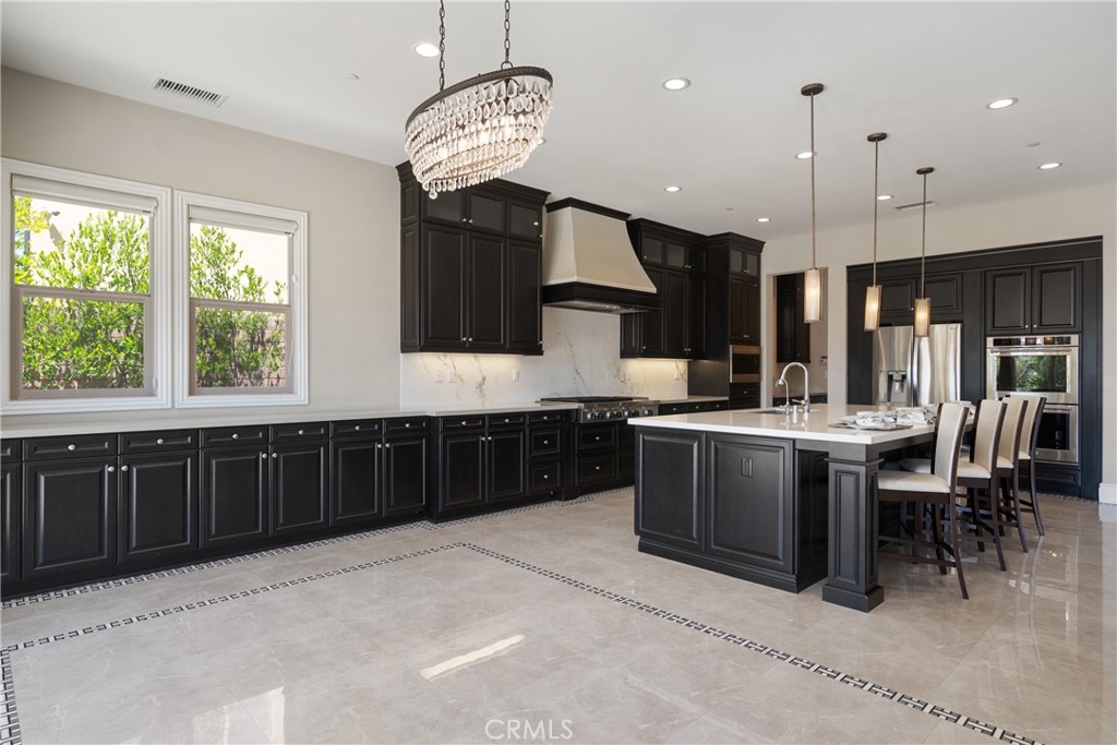 2498 Santa Paula Drive Brea, CA 92821 - Photo 27 of 75 a kitchen with stainless steel appliances granite countertop a stove top oven a sink dishwasher a dining table and chairs with wooden floor
