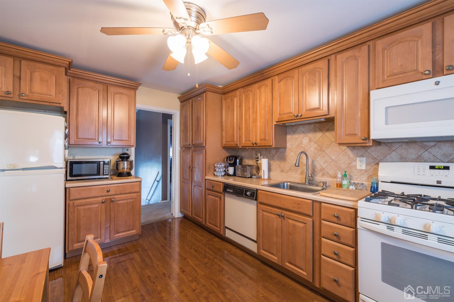 8 Wilk Road Edison, NJ 08837 - Photo 10 of 20 a kitchen with stainless steel appliances granite countertop a stove top oven a sink dishwasher and a refrigerator with wooden cabinets