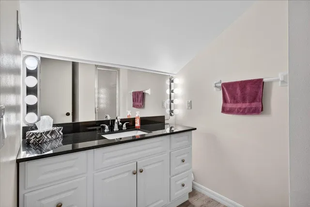 a bathroom with a granite countertop sink and a mirror