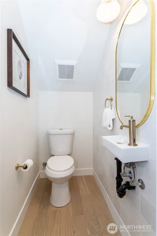 a bathroom with a toilet a sink and a mirror