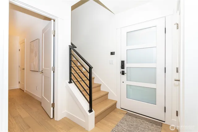 a view of a hallway with wooden floor and entryway