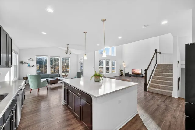 a open kitchen with stainless steel appliances granite countertop a sink stove and wooden floor