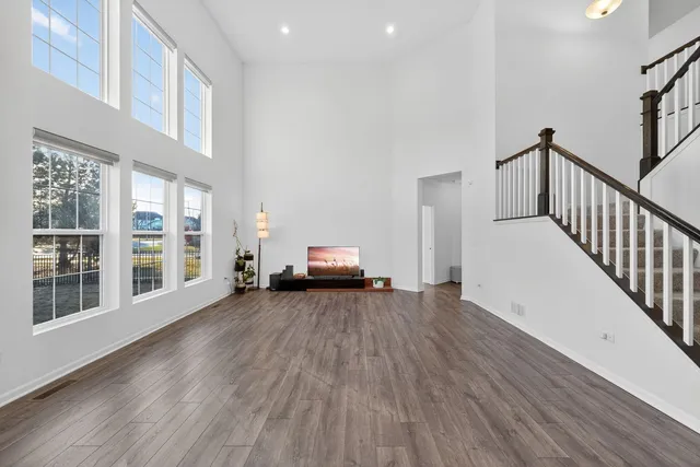 a view of a livingroom with wooden floor and a large window