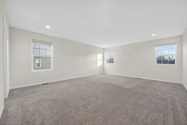 an empty room with windows and closet