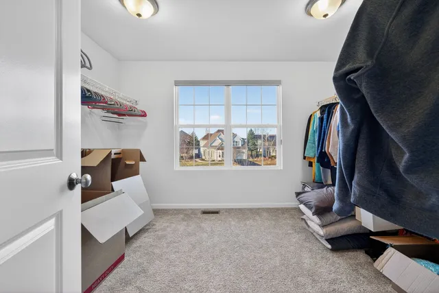 a view of walk in closet with clothes and shoes