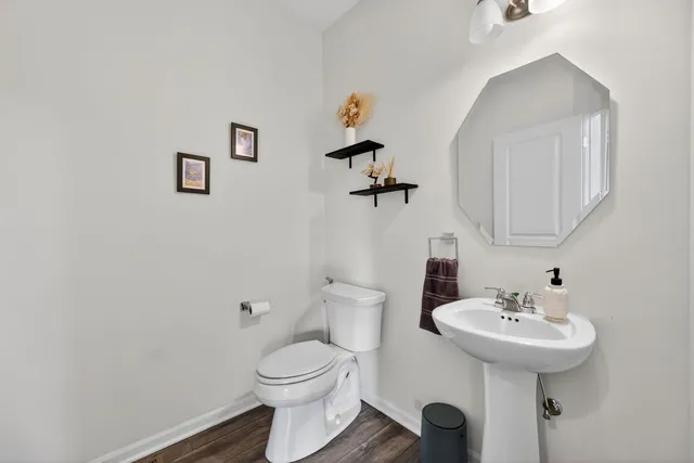 a bathroom with a toilet a sink and mirror
