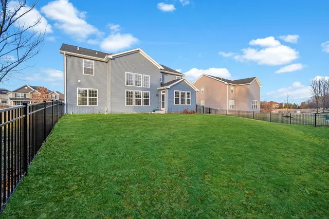 a view of a house with a big yard and large trees