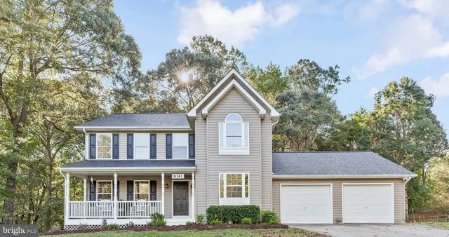 a front view of a house with yard and trees