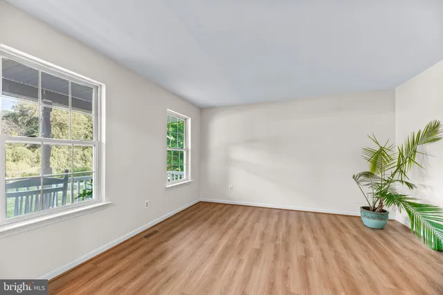 a view of a room with wooden floor and a window