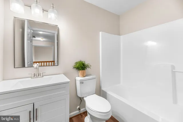 a bathroom with a sink a toilet a mirror and vanity