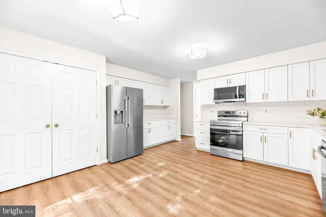 a kitchen with stainless steel appliances a refrigerator and a stove top oven