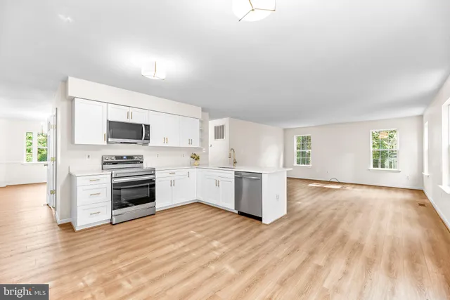 a kitchen with granite countertop a stove top oven and cabinets