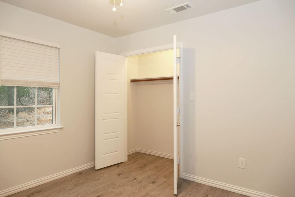 7311 Farm To Market Road 1886, Unit 101 Azle, TX 76020 - Photo 12 of 37 an empty room with wooden floor and windows