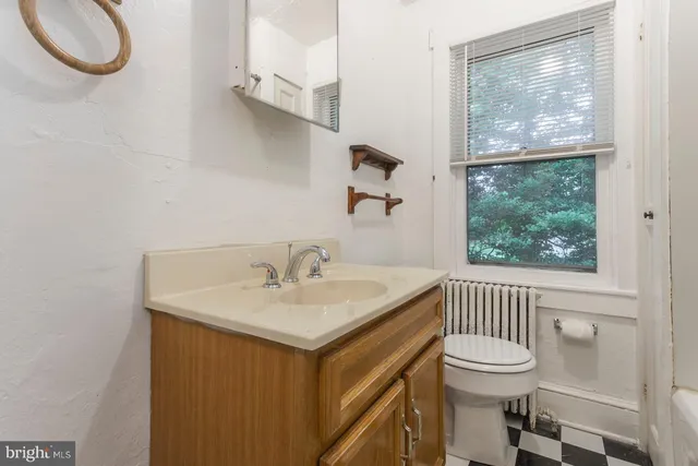 a bathroom with a sink a toilet and a window