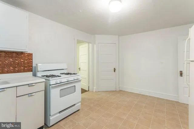 a kitchen with white cabinets and white appliances