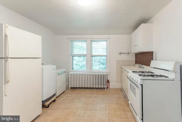 a kitchen with white cabinets and white appliances