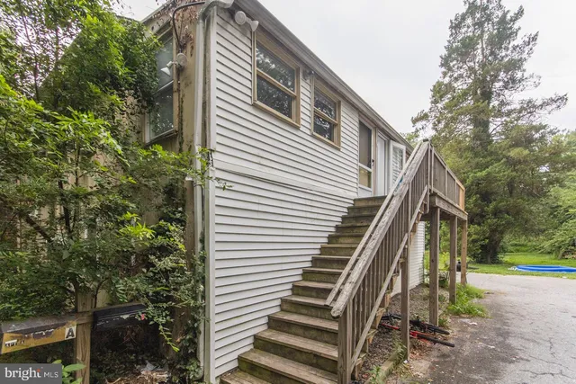 a view of a house with a yard and stairs