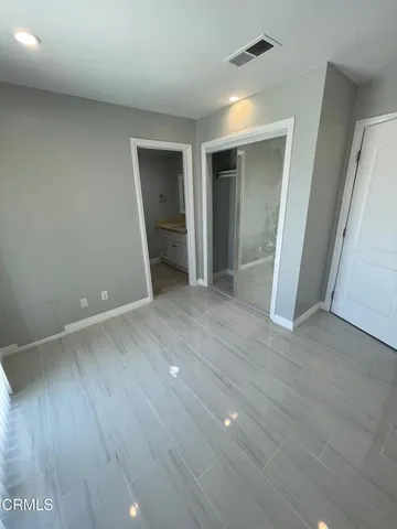 an empty room with wooden floor and closet