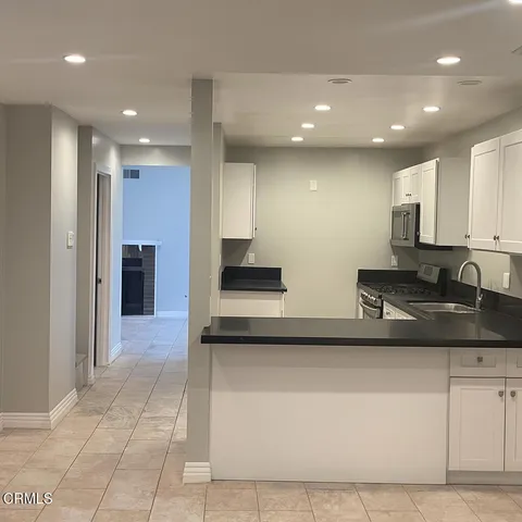 a kitchen with stainless steel appliances granite countertop a refrigerator and a stove