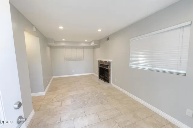an empty room with kitchen view and a window
