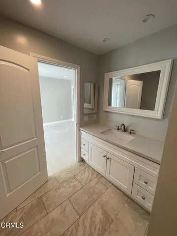 a spacious bathroom with a granite countertop sink a mirror and a