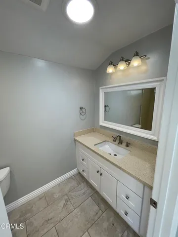 a bathroom with a sink vanity and mirror