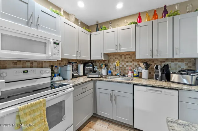 a kitchen with stainless steel appliances granite countertop a sink and cabinets