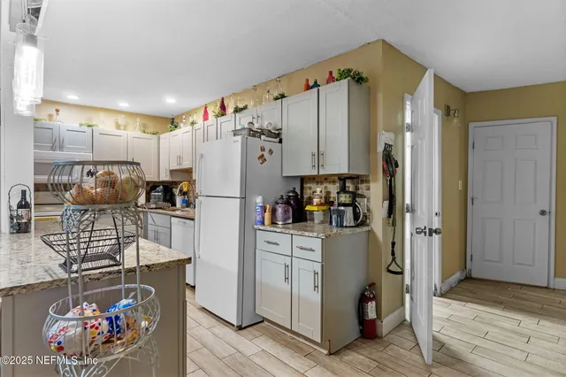 a kitchen with stainless steel appliances granite countertop a refrigerator and a stove