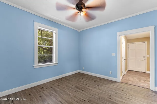 an empty room with a window and a fan