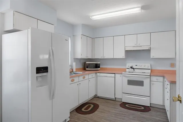 a kitchen with a refrigerator sink and cabinets
