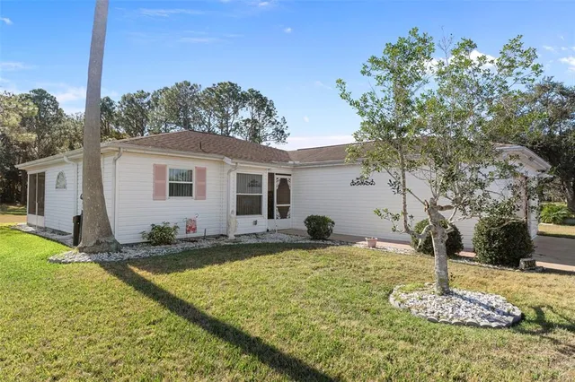 a view of a house with backyard and trees