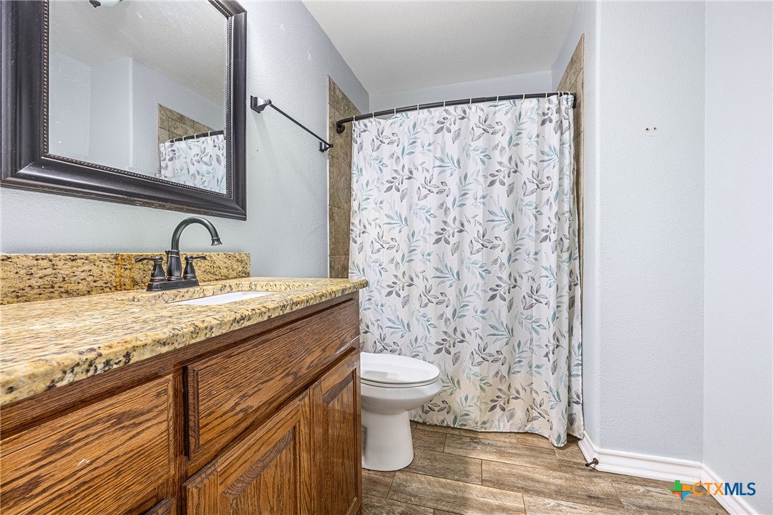 16101 Dove Road Moody, TX 76557 - Photo 25 of 42 a bathroom with a granite countertop sink toilet and a mirror