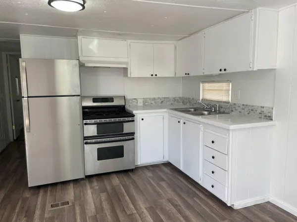 a kitchen with white cabinets and stainless steel appliances