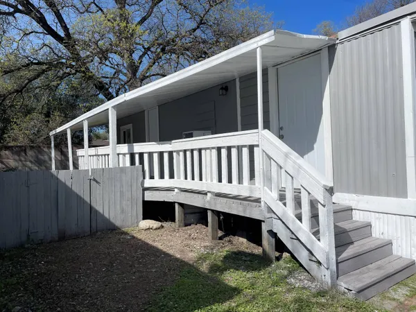 a view of a house with wooden deck and a yard