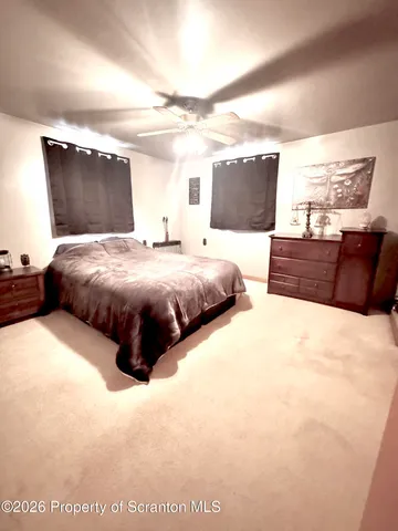 a bed sitting in a bedroom next to a window with lamp