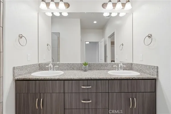 a bathroom with a granite countertop sink and a mirror
