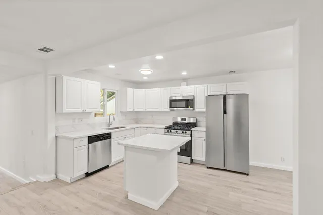 a kitchen with stainless steel appliances a refrigerator stove and sink
