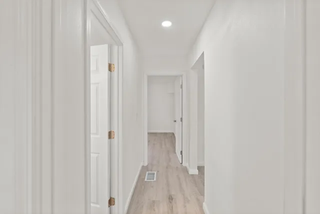a view of a hallway with wooden floor