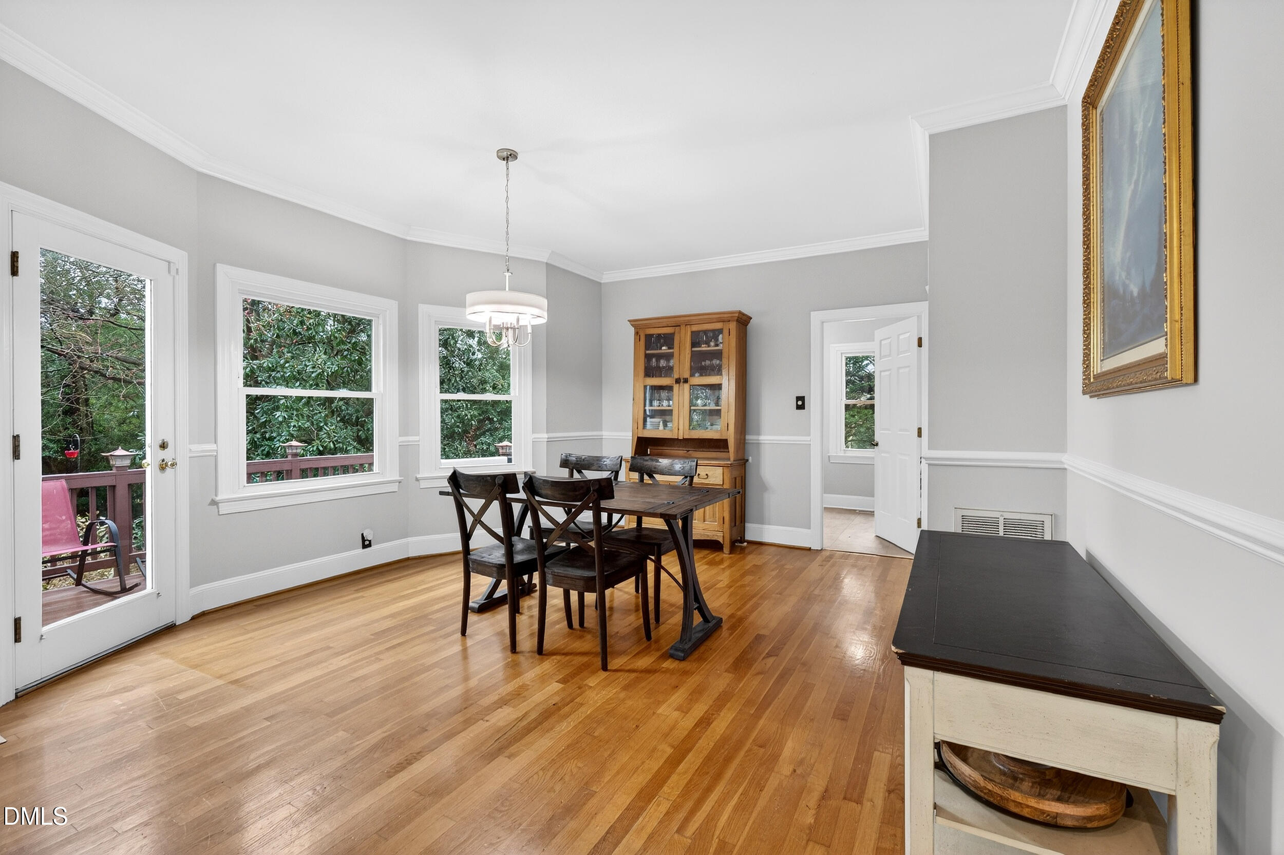 3735 Stoneybrook Drive Durham, NC 27705 - Photo 13 of 41 a dining room with wooden floor a chandelier a glass table and chairs