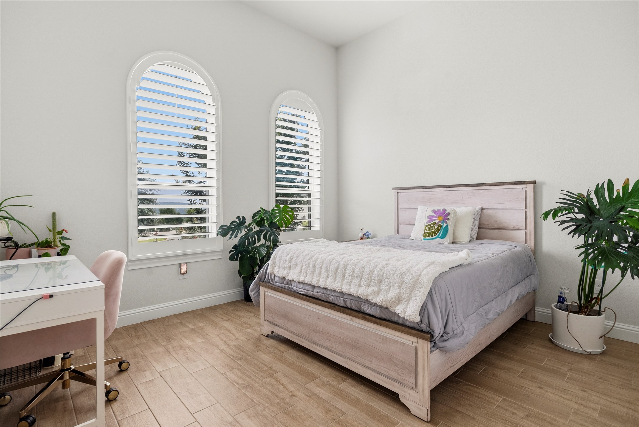 4513 Vieste View Leander, TX 78641 - Photo 35 of 40 Room featuring two arched windows with louvered shutters, light-toned walls, and wood-finish flooring