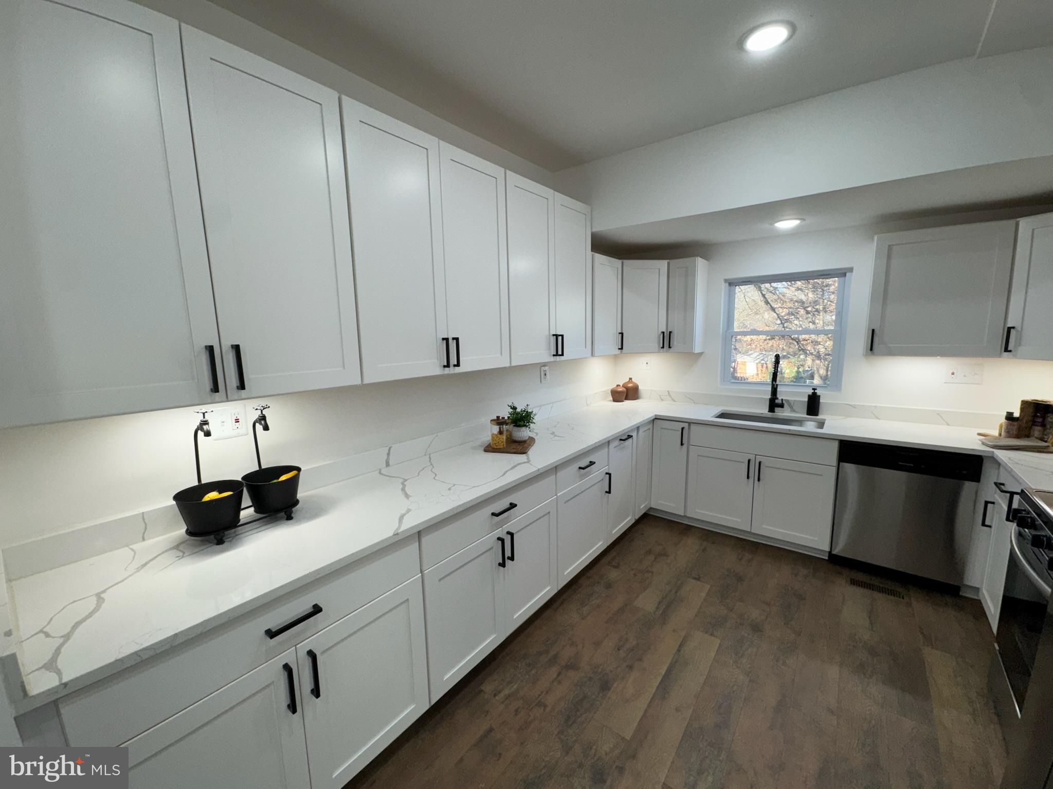 4116 32nd Street Mount Rainier, MD 20712 - Photo 13 of 51 a kitchen with a sink dishwasher a stove and white cabinets