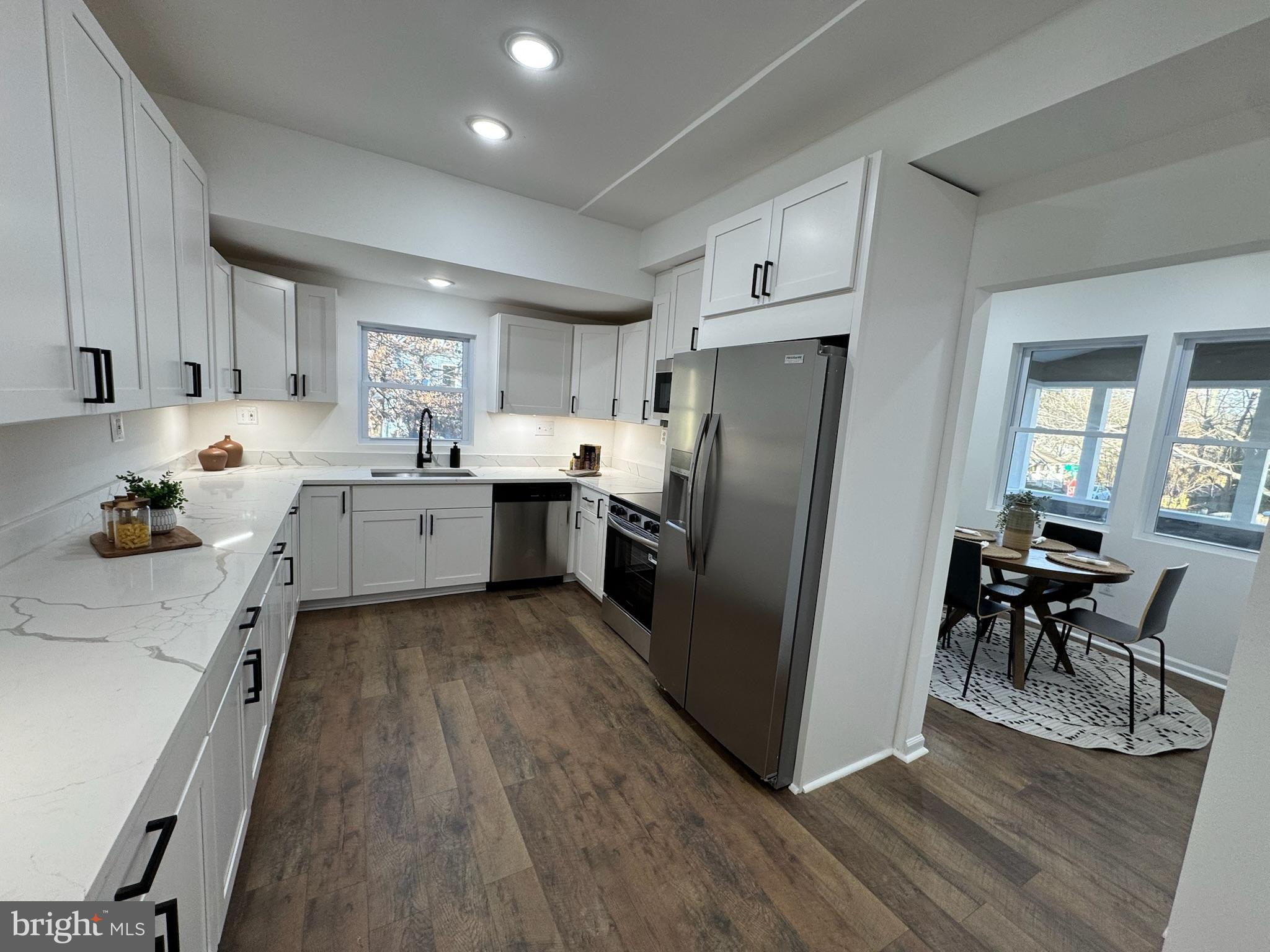 4116 32nd Street Mount Rainier, MD 20712 - Photo 16 of 51 a kitchen with granite countertop a refrigerator oven a sink dishwasher and white cabinets with wooden floor