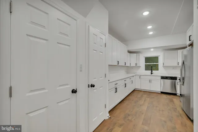 a kitchen with granite countertop white cabinets and sink