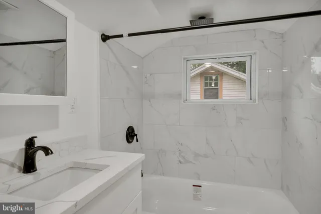 a bathroom with a sink a glass door and shower