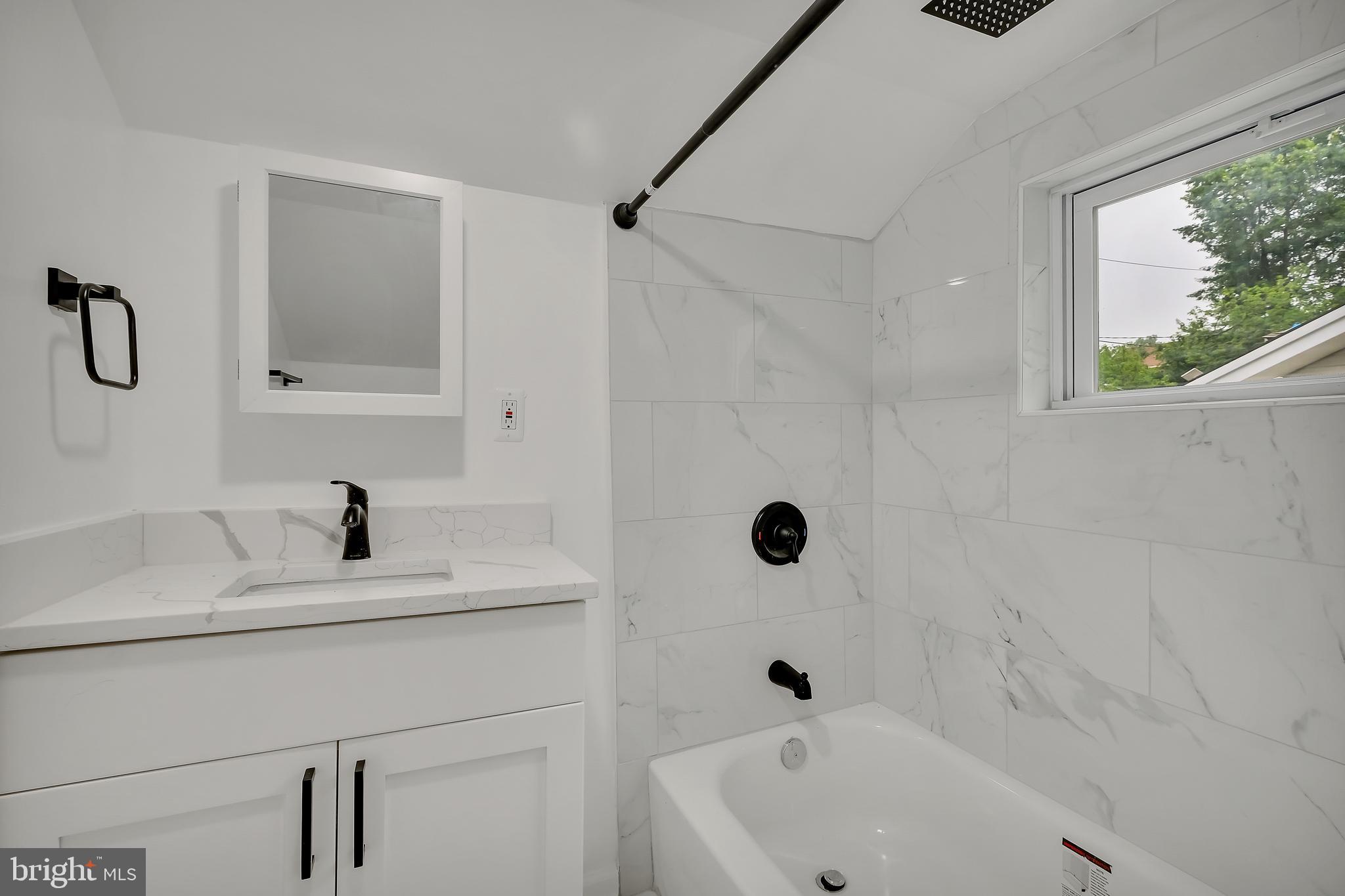 4116 32nd Street Mount Rainier, MD 20712 - Photo 37 of 51 a bathroom with a sink a mirror and a bathtub